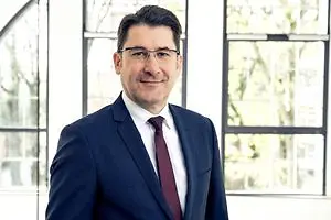 Ein Mann lächelt in die Kamera.