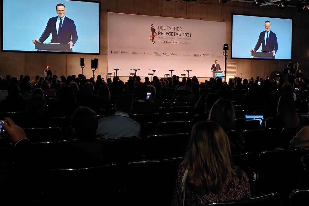 Herr Jens Spahn hält seine Rede vor mehreren, sitzenden Personen und Kameras.