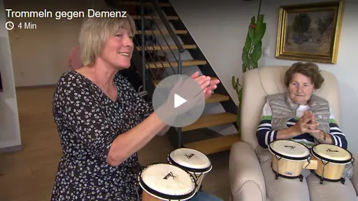 Zwei Frauen mit kleinen Trommeln auf dem Schoß.